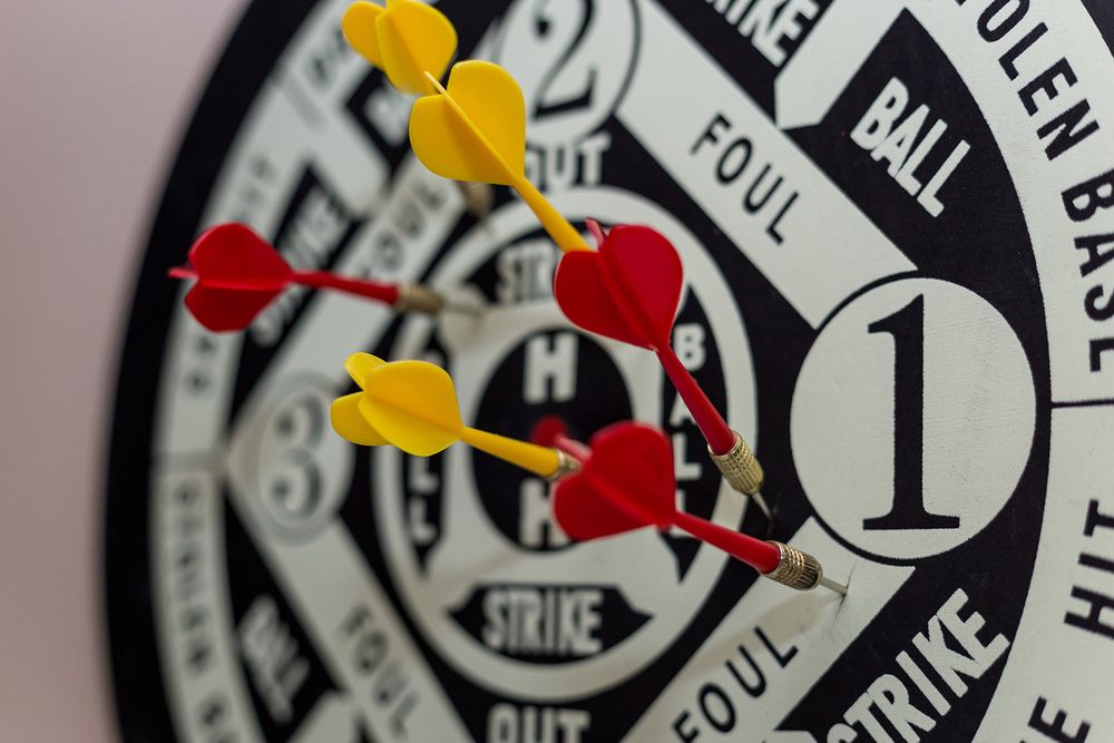 Rote und gelbe Darts in einer Dartscheibe